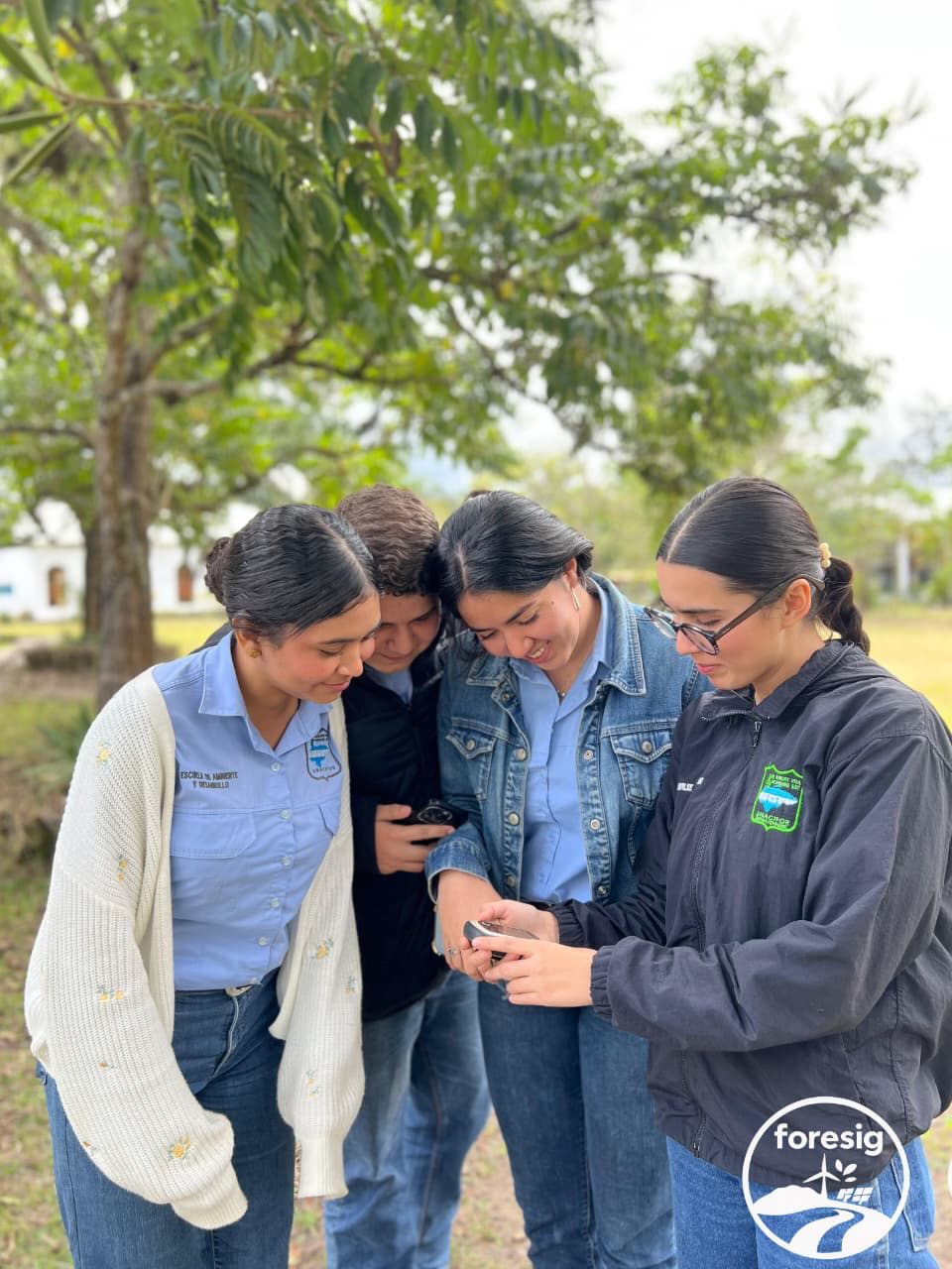 Estudiantes de UNACIFOR trabajando en equipo con un dispositivo de campo